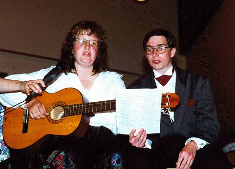 A couple singing and playing guitar